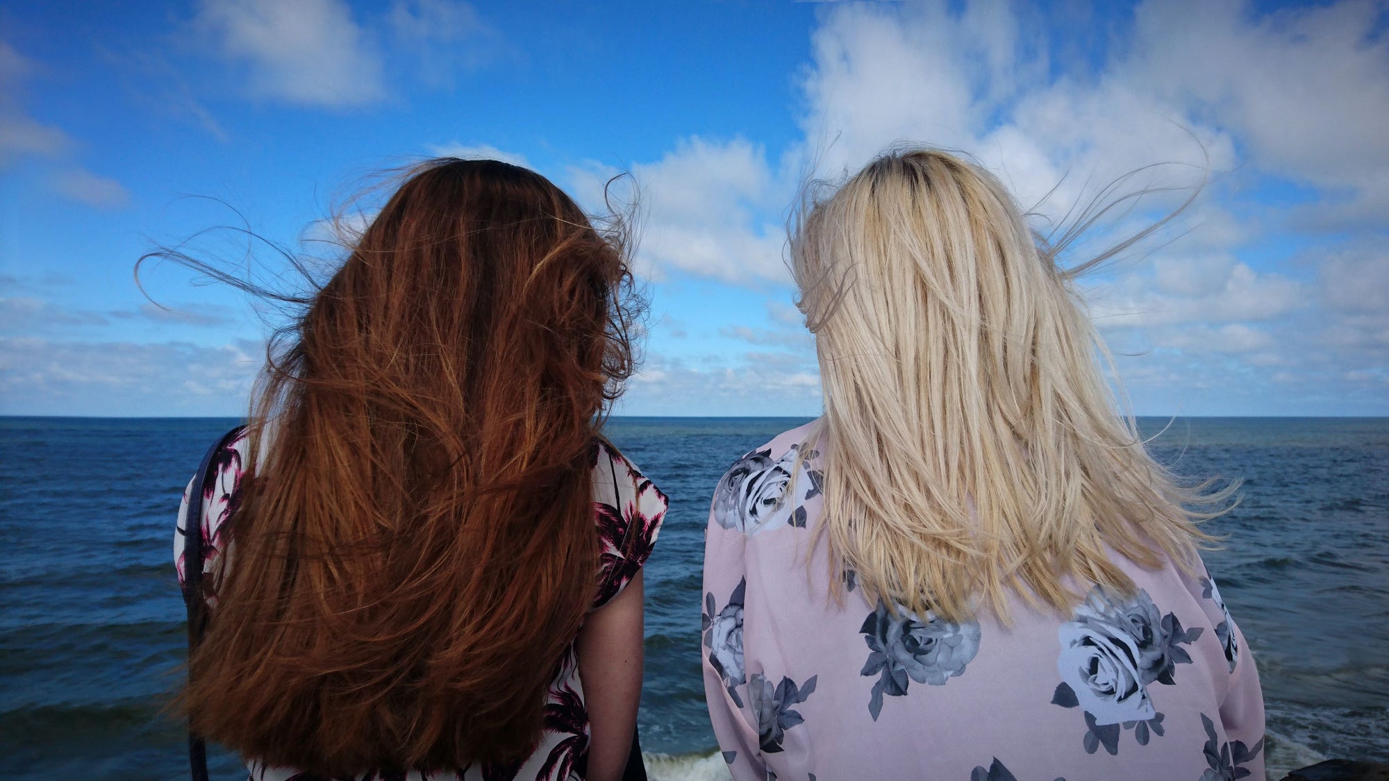 duas mulheres de costas com cabelos ao vento