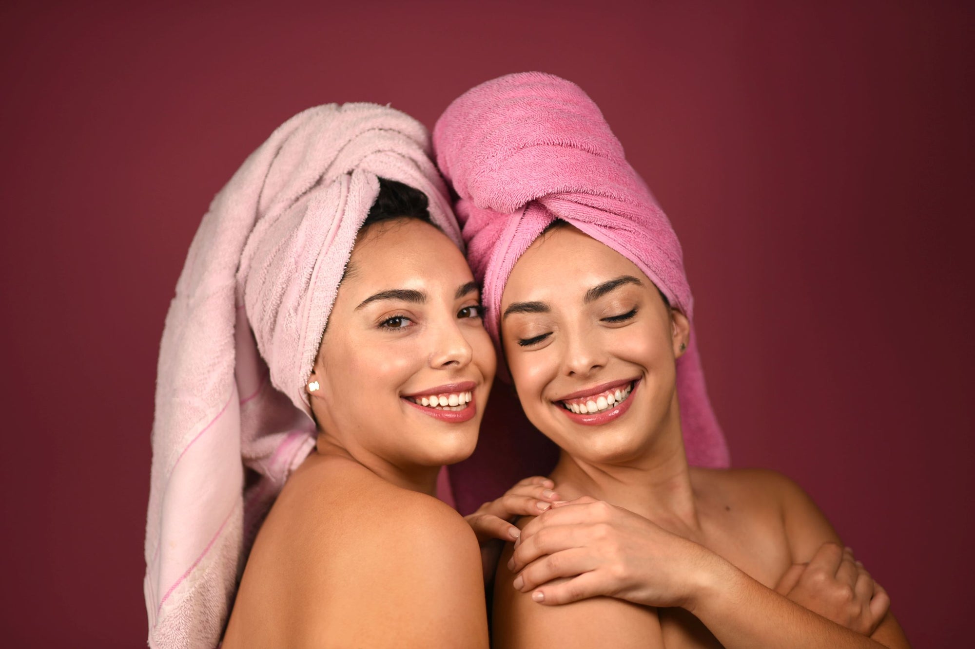 Duas mulheres com toalha enrolada no cabelo lavado.